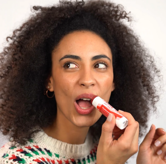woman applying treat beauty's candy apple jumbo lip balm