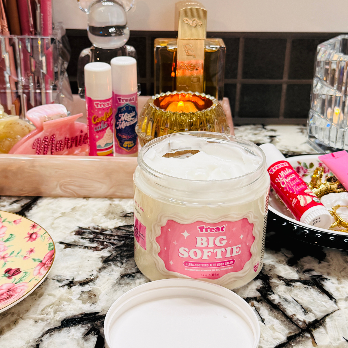 Jar of 'Big Softie' cream on a counter with various items in the background